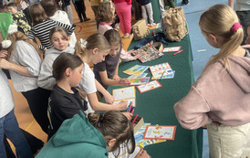Uczniowie na hali sportowej uczą się jak dbać o środowisko naturalne