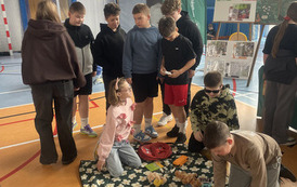 Uczniowie na hali sportowej segregują odpady
