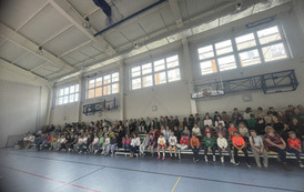 Uczniowie i nauczyciele na trybunach hali sportowej