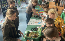 Uczniowie na hali sportowej uczą się jak dbać o środowisko naturalne