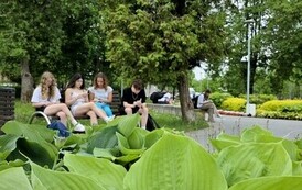 Uczennice klasy 8D czytają poezję w parku-na pierwszym planie rośliny