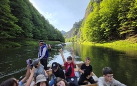 Uczniowie i flisacy na łodziach podczas spływu
