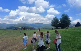 Grupa uczennic klasy 4B na polanie podziwia widoki