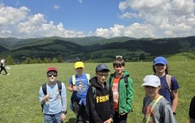 Grupa czwartoklasist&oacute;w na tle g&oacute;rskiego krajobrazu