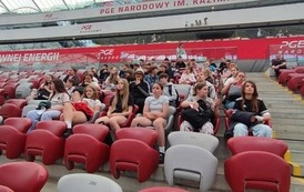 Uczniowie siedzą na trybunach Stadionu PGE Narodowego