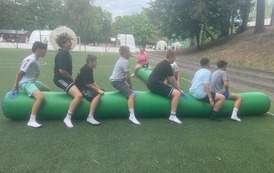 Uczniowie na pompowanej belce pr&oacute;bują dotrzeć do mety