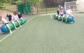 Uczniowie na pompowanej belce pr&oacute;bują dotrzeć do mety