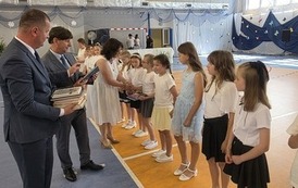 Dyrektor, wicedyrektor  i wychowawczyni wręczają nagrody książkowe uczniom klas trzecich