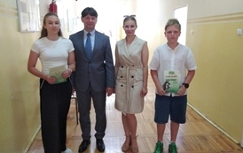 Dyrektor, przewodnicząca Rady Rodzic&oacute;w, dwoje uczni&oacute;w z dyplomami