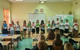 Grupa uczni&oacute;w czytająca tekst