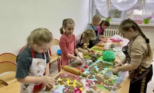 Dzieci z klasy 2 b w skupieniu wycinają kształty ciasteczek