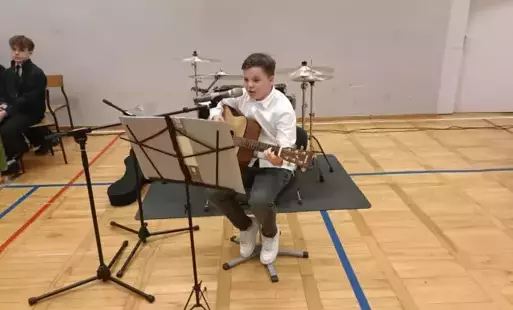 Uczeń grający na gitarze
