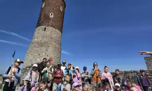 Uczestnicy wycieczki na tle zamkowej wieży