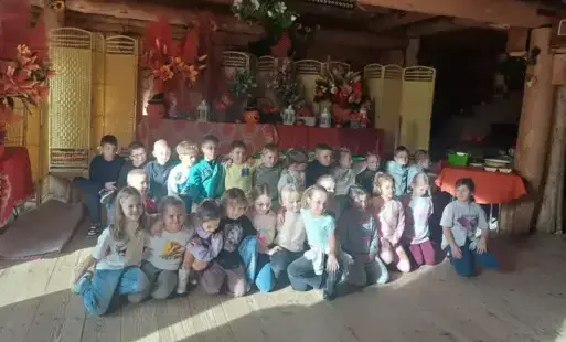 Zdjęcie grupowe klasy 1b w wiejskiej chacie w Dębnie
